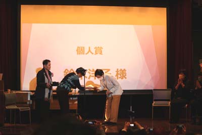 個人賞受賞者　鈴木洋子さんに表彰状を贈る審査会委員、渥美雅子さん