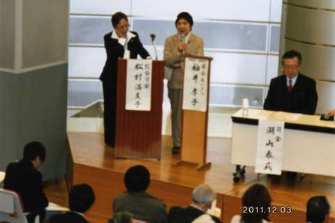 開会あいさつの袖井副理事長（右）と総合司会の松村理事